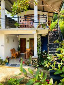 ein Haus mit einer Veranda und einer Terrasse in der Unterkunft Mellow Homestay in Ella