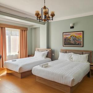 una camera da letto con due letti e un lampadario di Boudha Apart Hotel a Kathmandu
