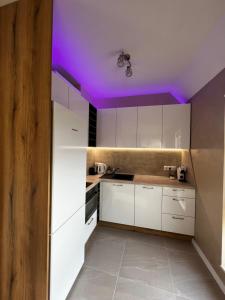 Una cocina con gabinetes blancos y un techo morado. en Varna downtown apartment, en Varna