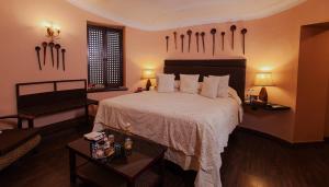 een slaapkamer met een groot bed met witte lakens en kussens bij The Ajit Bhawan - A Palace Resort in Jodhpur