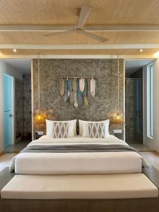 a bedroom with a large white bed with a ceiling at ANGKLA Beach Club & Boutique Resort in El Nido