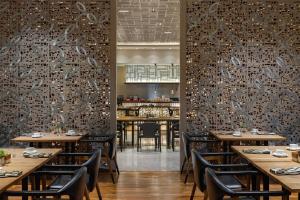 a restaurant with wooden tables and chairs and a bar at Alila Solo in Solo