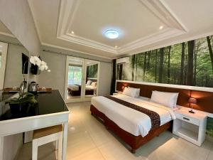 a bedroom with a bed and a desk and a window at The Taman Ayu in Seminyak