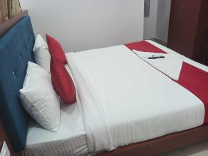 a bed with red and white pillows on it at OYO BRINDAVAN BEACH RESORT & RESTAURANT 