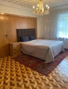 a bedroom with a large bed and a chandelier at 2 bedroom apartment close to Kaunas airport in Karmelava in Karmėlava