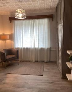 a living room with a chair and a window at 2 bedroom apartment close to Kaunas airport in Karmelava in Karmėlava