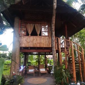 a tree house with a table and chairs in front of it at Dumaguete Treehouse in Dumaguete