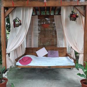 a bed in a tent with a pink hat on it at Dumaguete Treehouse in Dumaguete
