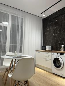 アスタナにあるRAISSON APARTHOTEL Sat CITY 145のキッチン(テーブル、洗濯機付) +8枚の写真