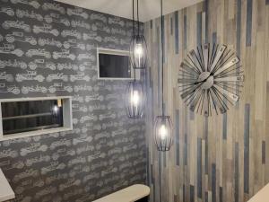 łazienka z trzema światłami i zegarem na ścianie w obiekcie Seaside Garage Shima - Vacation STAY 85765v w mieście Shima