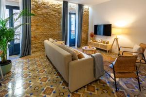 a living room with a couch and a tv at Empordanna, Apartamento con encanto en el corazón del Empordà in Torroella de Montgrí