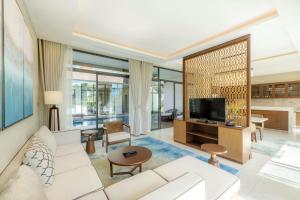 a living room with a white couch and a tv at Residence Inn Villa Cam Ranh in Cam Ranh