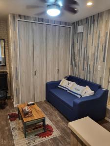 sala de estar con sofá azul y mesa en Seaside Garage Shima - Vacation STAY 77073v en Shima