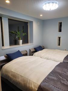 Un dormitorio con 2 camas y una ventana con una maceta. en Seaside Garage Shima - Vacation STAY 77073v en Shima