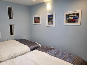 Seaside Garage Shima - Vacation STAY 77073v في شيما: غرفة نوم بسريرين وصور على الحائط