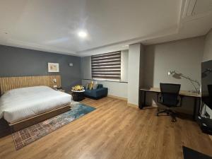 a bedroom with a bed and a desk and a computer at Gumi Century Hotel in Gumi