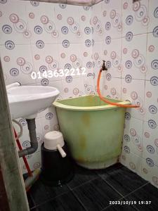 y baño con bañera y lavamanos. en Ekaira homestay en Tambun