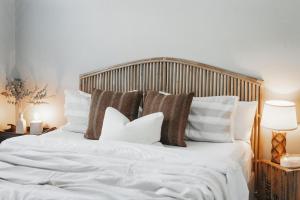Una cama con sábanas blancas y almohadas. en La Mia Casa 159 - The Entertainer, en Orange