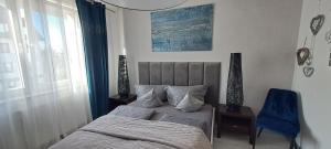 um quarto com uma cama e uma cadeira azul em Apartament-Sweet Night em Lubin