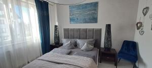 sypialnia z łóżkiem i niebieskim krzesłem w obiekcie Apartament-Sweet Night w Lubinie