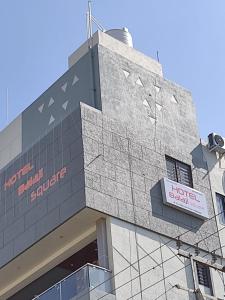 een gebouw met een bord aan de zijkant bij HOTEL BALAJI SQUARE in Porbandar