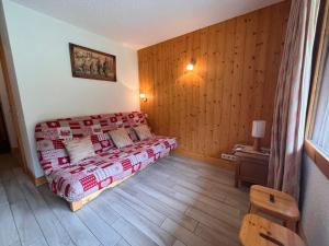 a bedroom with a bed and a wooden wall at Appartement Méribel, 2 pièces, 5 personnes - FR-1-355-247 in Les Allues