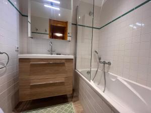 a bathroom with a tub and a sink and a shower at Appartement Méribel, 2 pièces, 5 personnes - FR-1-355-247 in Les Allues