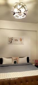 1 dormitorio con cama y lámpara de araña en Redbean Guesthouse, en Wujie