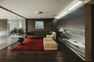 uma sala de estar com um sofá e um tapete vermelho em Liardet22 The Penthouse em New Plymouth