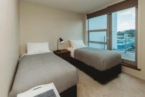 a hotel room with two beds and a window at Liardet22 The Penthouse in New Plymouth