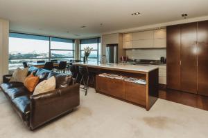 a living room with a couch and a kitchen at Liardet22 The Penthouse in New Plymouth