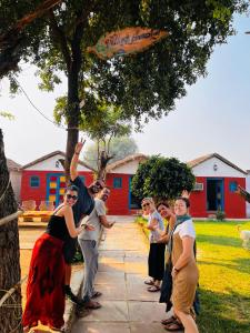 un grupo de personas disfrazadas de pie bajo un árbol en Backpackers Village Agra, en Agra