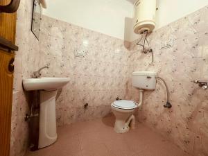 ein Bad mit einem WC und einem Waschbecken in der Unterkunft Hotel Alpine in Manali