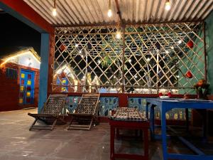 Backpackers Village Agra في آغْرا: غرفة بها كرسيين وحائط من زجاجات النبيذ