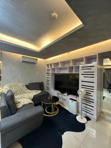 un soggiorno con divano e TV di Condo in Taguig, 2br condo, Acacia Estates, BGC, a Manila