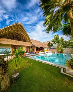 a resort with a swimming pool and palm trees at Villa Kasadya in Panglao