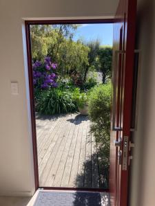 an open door with a view of a garden at Brighton Beach in Dunedin