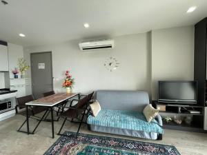a living room with a couch and a table at The Base Central Pattaya apartments in Pattaya Central