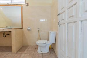 Funny homestay 2 في غيلي تراوانغان: حمام به مرحاض أبيض ومرآة