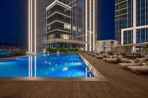 a hotel with a swimming pool in front of a building at Grand HiLai Taipei in Taipei