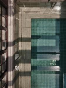 a swimming pool with a reflection in the water at Capella Shanghai, Jian Ye Li in Shanghai