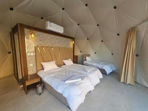 a bedroom with two beds in a tent at غرووب وادي رم in Wadi Rum