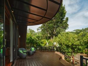 a deck with a table and chairs on a house at The Hidden Village, Khao Yai in Mu Si