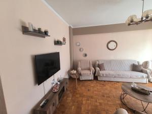 a living room with a couch and a tv at Vaso holidays in Alexandroupoli