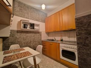a kitchen with wooden cabinets and a table with chairs at Vaso holidays in Alexandroupoli