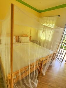 a bedroom with a bed with a mosquito net at Lights of kazinga orphanage and homestay in Rubirizi
