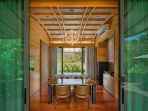 a dining room with a table and chairs and a window at The Hidden Village, Khao Yai in Mu Si