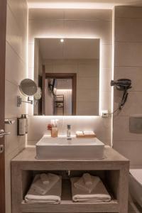 La salle de bains est pourvue d'un lavabo et d'un miroir. dans l'établissement IRA - ΗΡΑ City Hotel, à Kalamata