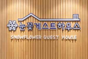 a snowflower guest house sign on a wooden wall at Snowflower Guesthouse in Seoul