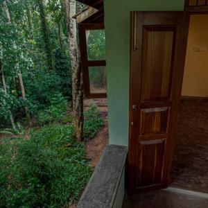 une porte ouverte d'une maison avec une fenêtre dans l'établissement Weralugama Forest House, 